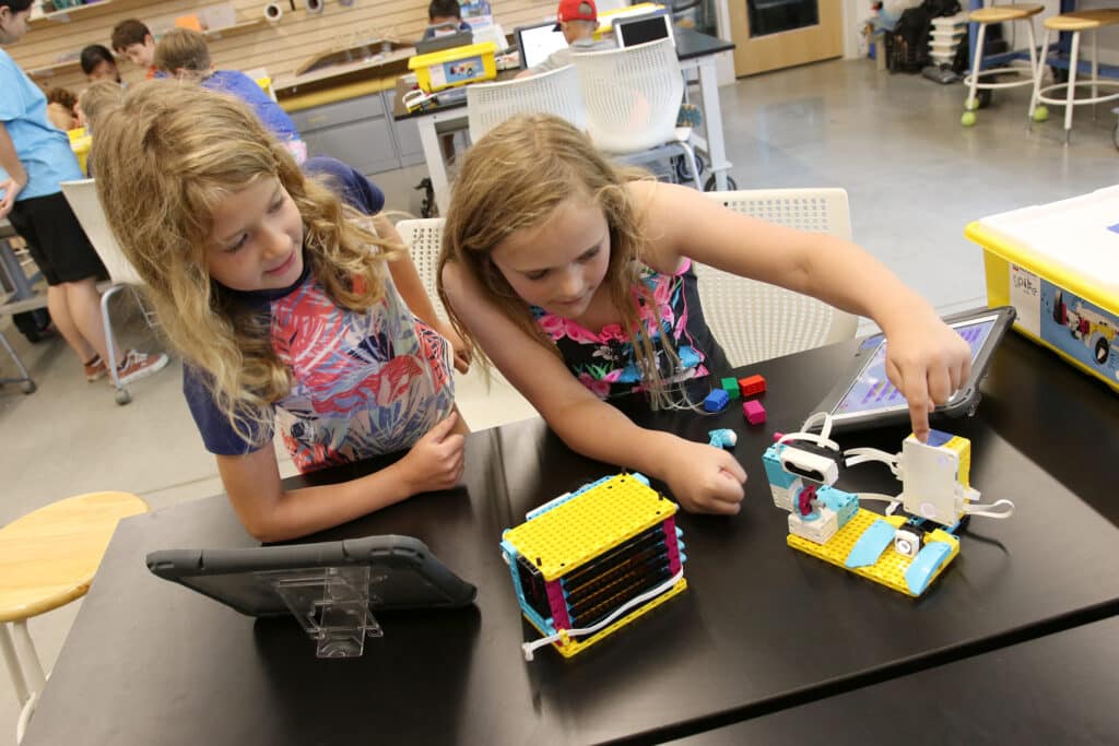 Two campers work on a robotics activity at STEM camp