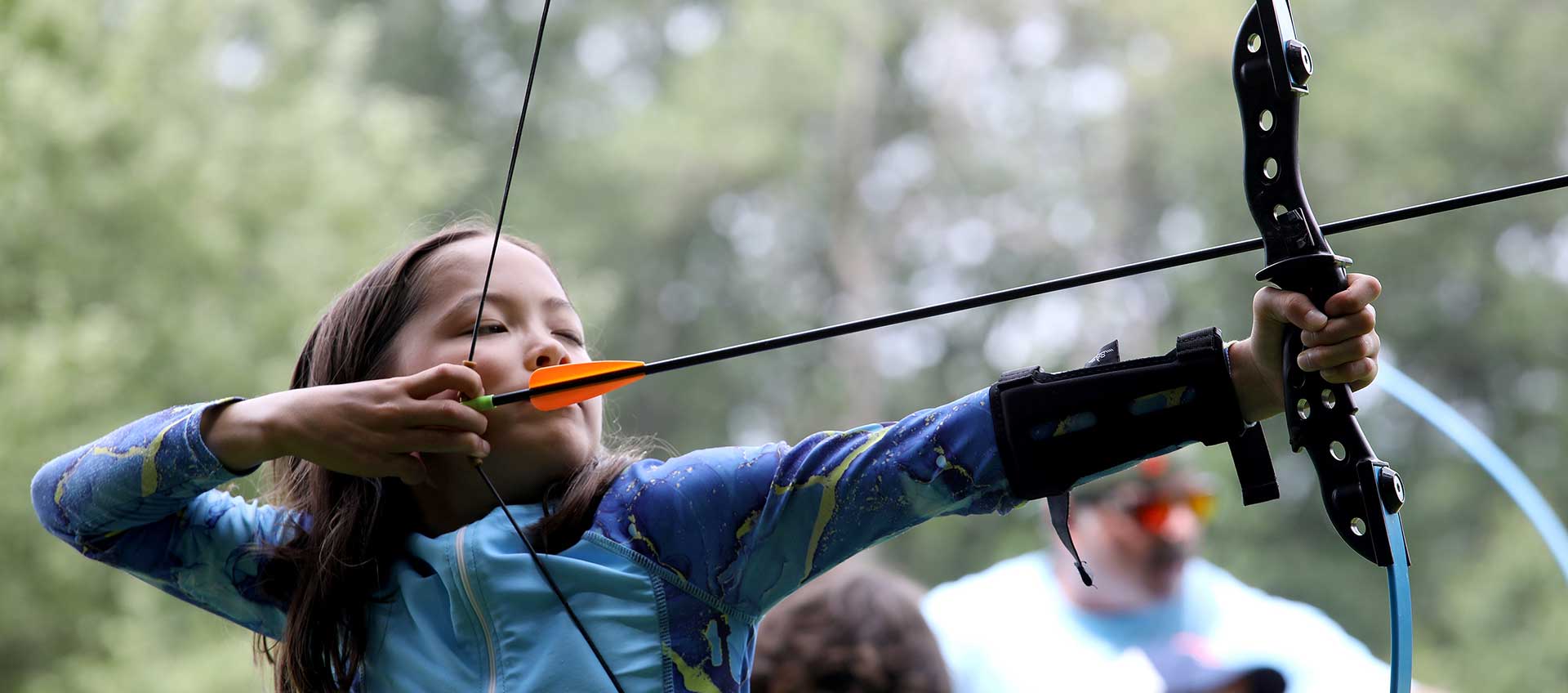 A camper takes aim on the archery ground